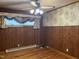 Cozy bedroom with wood-paneled walls, ceiling fan and hardwood floors at 417 Sunnyview Rd, Henderson, NC 27536