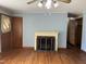 Cozy living room with hardwood floors, fireplace, and ceiling fan with a light fixture at 417 Sunnyview Rd, Henderson, NC 27536