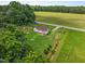 Aerial view of a charming home, lush green lawn and surrounding tree line and green pasture at 4240 Friendship Rock Creek Rd, Burlington, NC 27215