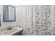 Updated bathroom with a gray sink cabinet, mirror, and butterfly shower curtain at 4240 Friendship Rock Creek Rd, Burlington, NC 27215