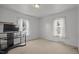 Bright bedroom with two windows, neutral carpet, and TV on a rolling stand at 4240 Friendship Rock Creek Rd, Burlington, NC 27215