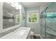 Bathroom with a modern vanity, sink, and a walk-in shower with glass doors and views to the outside at 430 Walnut St, Cary, NC 27511