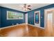 Bedroom featuring a ceiling fan, hardwood floors, blue walls and lots of natural light from the windows at 430 Walnut St, Cary, NC 27511