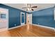 Spacious bedroom featuring blue walls, hardwood floors, a ceiling fan, and multiple closets and doors at 430 Walnut St, Cary, NC 27511