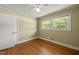 Bedroom showcasing hardwood floors, neutral walls, a ceiling fan, and a window providing natural light at 430 Walnut St, Cary, NC 27511
