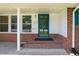 Inviting front porch with brick steps leads to a stylish green door and white trim at 430 Walnut St, Cary, NC 27511