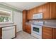 Kitchen featuring wood cabinets, stainless steel microwave, stove, dishwasher, tile backsplash and outdoor access at 430 Walnut St, Cary, NC 27511