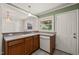 A view of the kitchen featuring wood cabinets, a sink, a dishwasher, and access to an adjacent dining area at 430 Walnut St, Cary, NC 27511