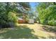 Expansive, tree-lined backyard with well-maintained lawn and outbuildings at 4412 Green Spring Dr, Garner, NC 27529
