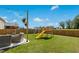 Fenced backyard with a playset, string lights, patio and green grass at 444 Campbell Ridge Pl, Wendell, NC 27591