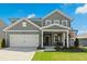Charming two-story home with gray siding, a welcoming front porch, and a well-maintained front lawn at 444 Campbell Ridge Pl, Wendell, NC 27591