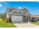 Two story home with gray siding, white trim, two car garage, and landscaped front yard at 444 Campbell Ridge Pl, Wendell, NC 27591