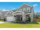 Two story home with gray siding, white trim, landscaped yard and a charming front porch at 444 Campbell Ridge Pl, Wendell, NC 27591