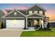 Charming two-story home with gray siding, white trim, a welcoming front porch, and a two car garage at 444 Campbell Ridge Pl, Wendell, NC 27591