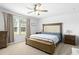 Cozy main bedroom features neutral tones, a ceiling fan, ample natural light, and comfortable furnishings at 444 Campbell Ridge Pl, Wendell, NC 27591