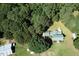 Aerial view of a house with a green metal roof surrounded by mature trees and lawn at 4822 Nc Highway 98 W, Youngsville, NC 27596