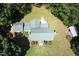 Aerial view of house with a green metal roof surrounded by mature trees and lawn at 4822 Nc Highway 98 W, Youngsville, NC 27596