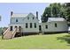 Well-maintained lawn and backyard featuring a lovely country house with stone foundation and stairs to the deck at 4822 Nc Highway 98 W, Youngsville, NC 27596