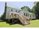 View of well-maintained lawn and backyard featuring deck attached to a lovely country house with stone foundation at 4822 Nc Highway 98 W, Youngsville, NC 27596
