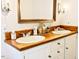 Bathroom features double sinks with a wood counter and white cabinets at 4822 Nc Highway 98 W, Youngsville, NC 27596