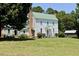 Side view of house with green roof, mature trees, brick chimneys, and outbuilding at 4822 Nc Highway 98 W, Youngsville, NC 27596