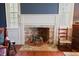 Close up of brick fireplace with rocking horse, red chair, and vintage décor at 4822 Nc Highway 98 W, Youngsville, NC 27596