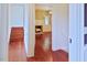 Hallway with wooden floors leading to a sunlit room, showcasing the home's inviting layout at 4822 Nc Highway 98 W, Youngsville, NC 27596