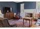 Cozy living room featuring vintage furniture, blue walls, and fireplace at 4822 Nc Highway 98 W, Youngsville, NC 27596
