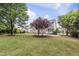 Spacious backyard with lush lawn, mature trees, and a patio at 501 Ivyshaw Rd, Cary, NC 27519