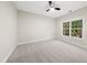 Bright bedroom with neutral carpet, a ceiling fan, and a large window overlooking the home's backyard at 501 Ivyshaw Rd, Cary, NC 27519