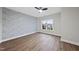 A bright bedroom features a decorative accent wall, wood-look flooring, and a view to the front at 501 Ivyshaw Rd, Cary, NC 27519