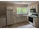 Functional kitchen features white cabinets, countertops, modern appliances and view of backyard at 501 Morgan Ter, Burlington, NC 27217
