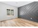 Bedroom features a decorative wall, light wood floors, and a bright window at 5027 Preacher Holmes Rd, Graham, NC 27253