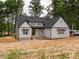 Charming two-story home with a gabled roof, light gray siding, black trim, and wooded surrounding at 5027 Preacher Holmes Rd, Graham, NC 27253