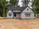 New construction featuring light gray siding, a dark roof, a landscaped yard, and a welcoming front entry at 5027 Preacher Holmes Rd, Graham, NC 27253