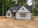 Charming two-story home with a gabled roof, light gray siding, and black trim at 5027 Preacher Holmes Rd, Graham, NC 27253