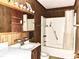 Modest bathroom featuring a single sink vanity, wood paneling, and a shower-tub combo at 525 Locust Rd, Hillsborough, NC 27278