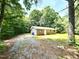 Exterior angle of brick home with ample yard space and mature trees in background at 525 Locust Rd, Hillsborough, NC 27278