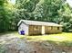 Exterior view of single story brick home with lawn, trees and gravel driveway at 525 Locust Rd, Hillsborough, NC 27278