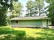 Green exterior view of a home featuring a single window and a door in a grassy area at 525 Locust Rd, Hillsborough, NC 27278
