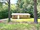 Exterior shot of a brick home with a gravel driveway framed by trees at 525 Locust Rd, Hillsborough, NC 27278
