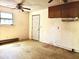Bright living room featuring a doorway, window, ceiling fan, and outdated cabinets at 525 Locust Rd, Hillsborough, NC 27278
