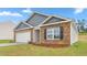 Cozy home with brick and siding, showcasing a well-maintained lawn and an attached garage at 528 Lochalsh Dr, Gibsonville, NC 27249