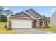 Charming single-story home featuring a brick facade, gray siding, and an attached two-car garage at 528 Lochalsh Dr, Gibsonville, NC 27249