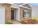 Welcoming front entrance showcasing brickwork, white siding, and a black front door and window shutters at 528 Lochalsh Dr, Gibsonville, NC 27249