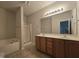Bathroom featuring double sinks, wood cabinets, and a shower with glass door at 6408 Bunker Hill Dr, Raleigh, NC 27610