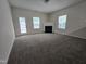 Spacious living room featuring a fireplace, carpet flooring, and a door to backyard at 6408 Bunker Hill Dr, Raleigh, NC 27610