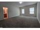 Large main bedroom featuring carpet flooring, two windows, and an ensuite bathroom at 6408 Bunker Hill Dr, Raleigh, NC 27610