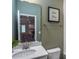 Well-lit bathroom featuring a single sink with a modern faucet, framed mirror, and olive green wall at 668 Ben Ledi Ct, Raleigh, NC 27603