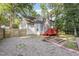 Backyard with a red deck, garden beds, wooden fence, and gravel at 716 Beddingfield Dr, Knightdale, NC 27545